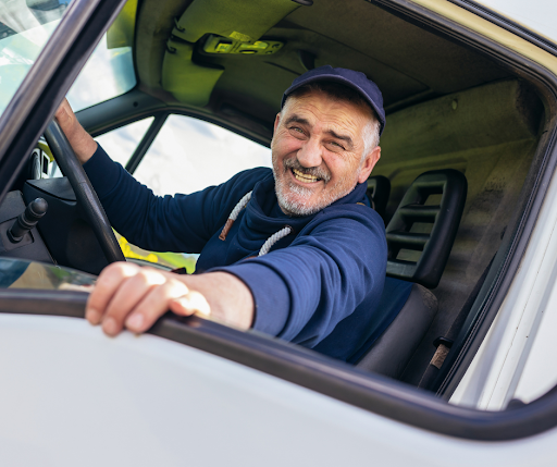 A BTI professional company truck driver in his flatbed truck cab.